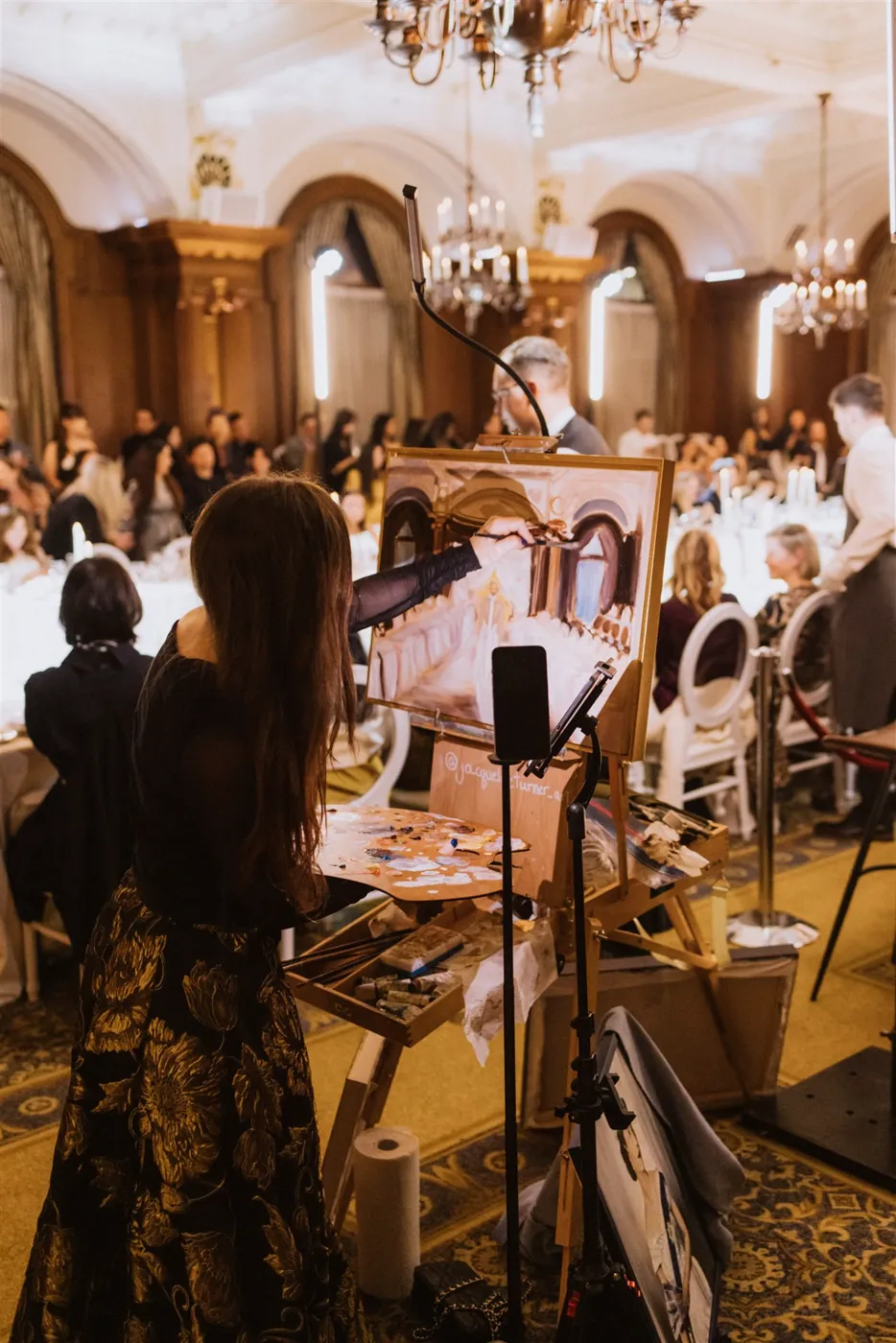 Close-up of the La Marie runway painting in progress, guests watching
