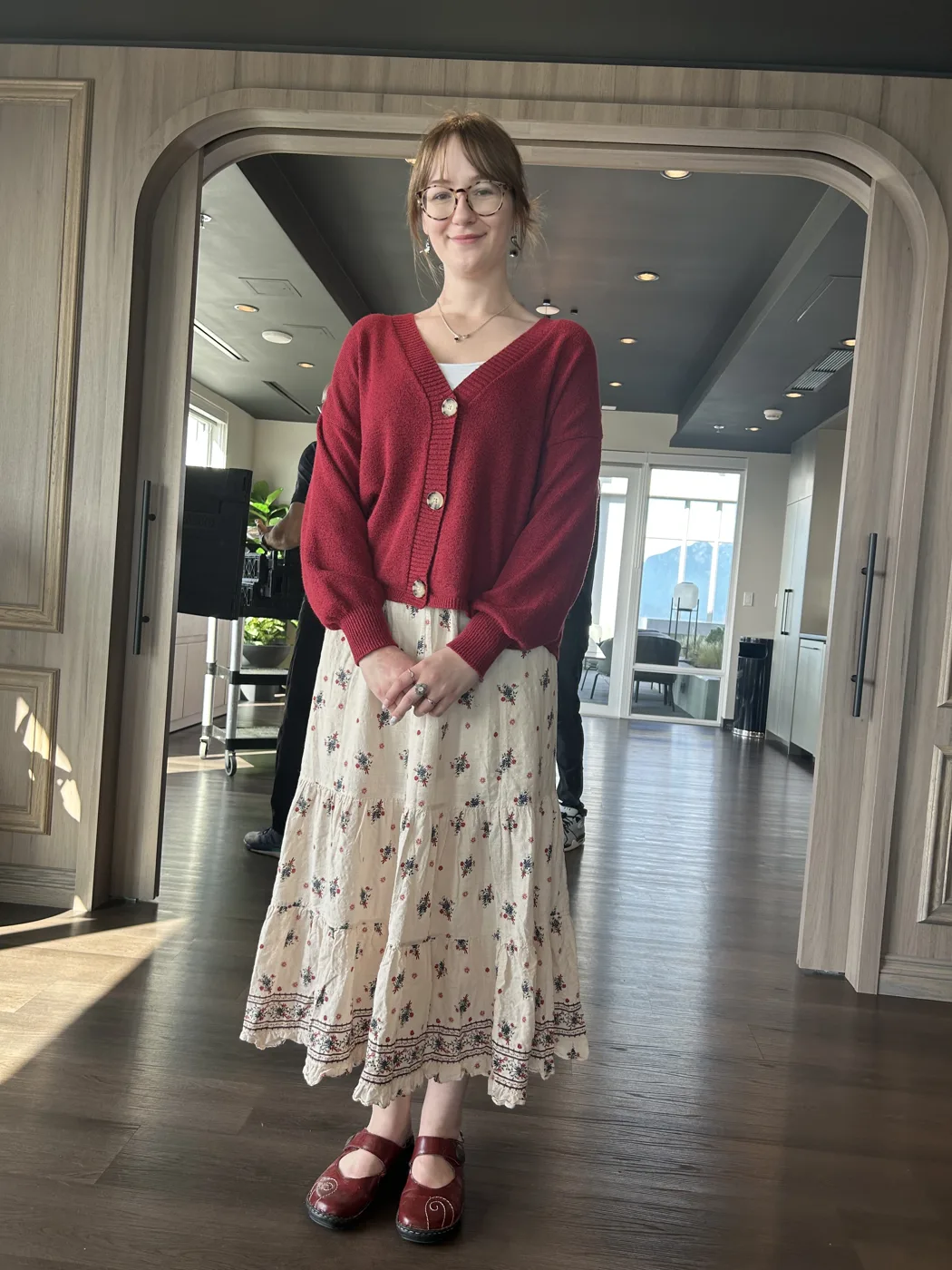 Guest in a red sweater posing for her photo at a corporate event