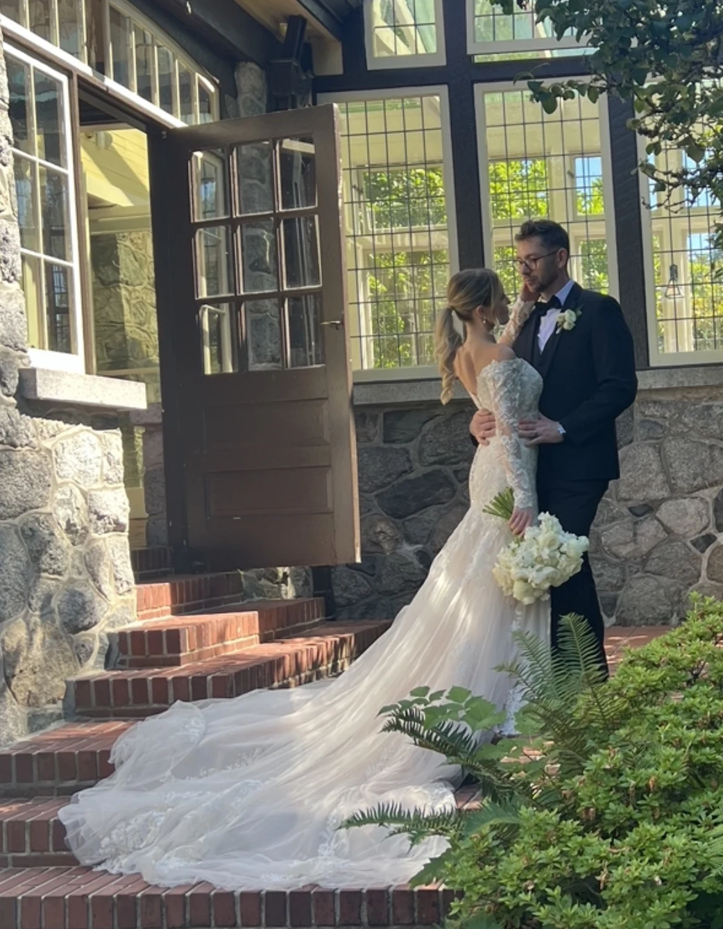 Bride and groom together at the stone doorway, the moment depicted in their wedding painting