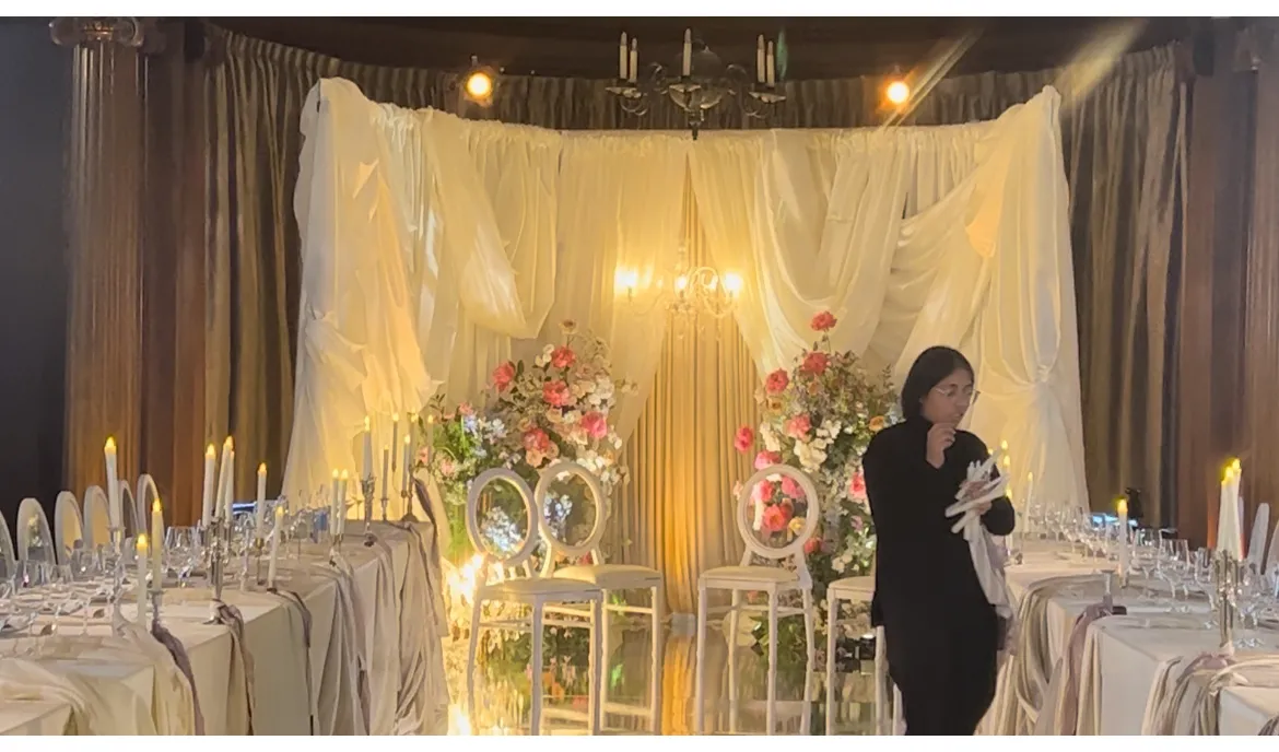 The runway stage at The Vancouver Club draped in white silk with chandeliers and roses